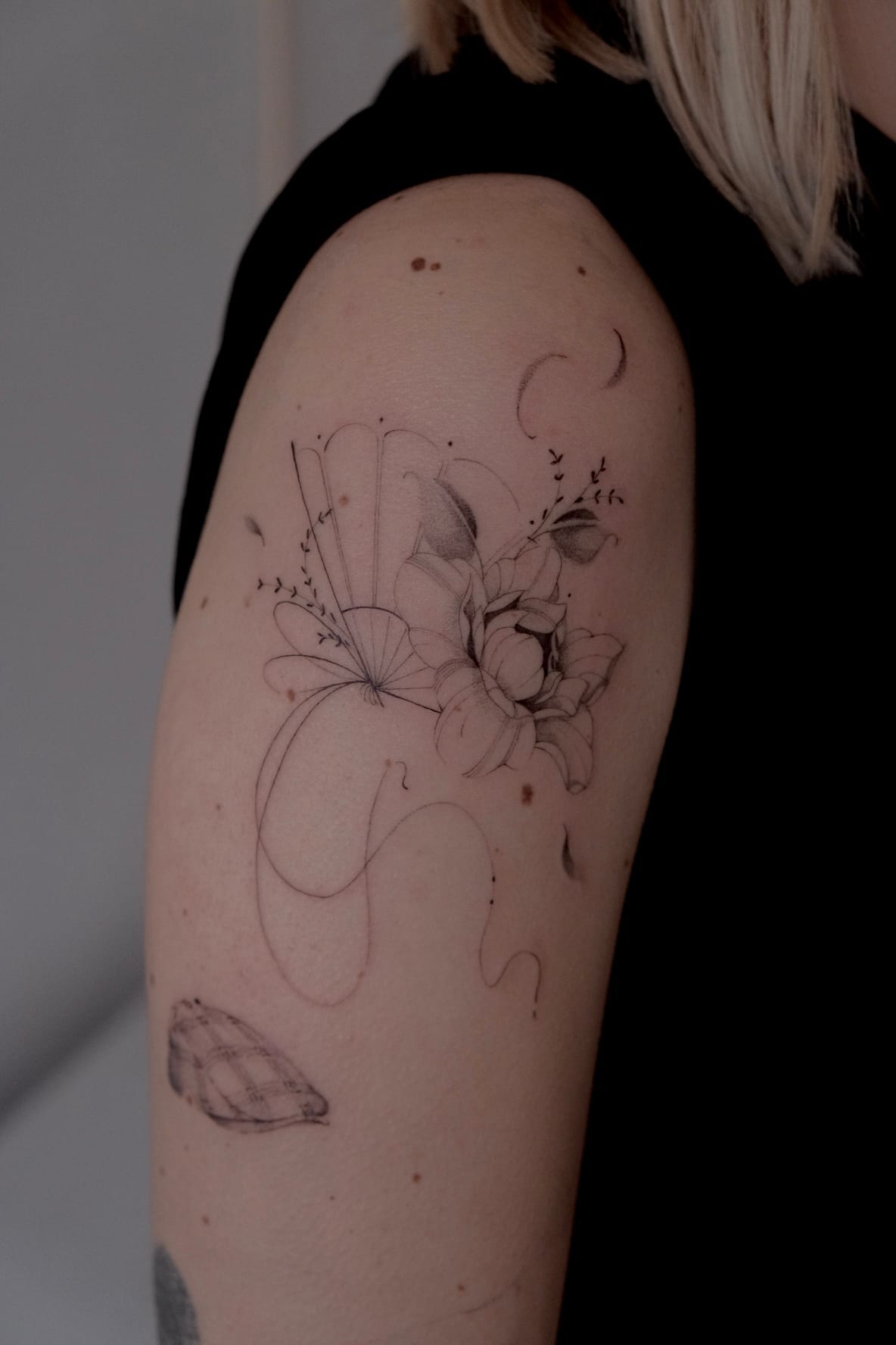 Fine line flower on the back of the upper arm