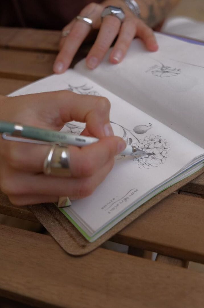 Hands sketching in the studio sketchbook